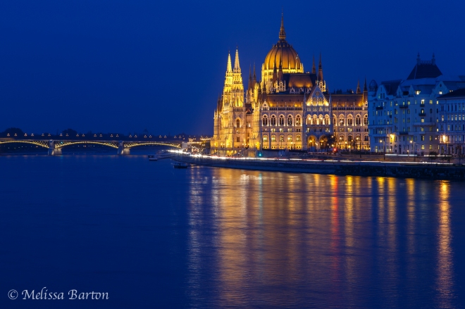 A photograph of the Hungarian Parliament building lit up at night